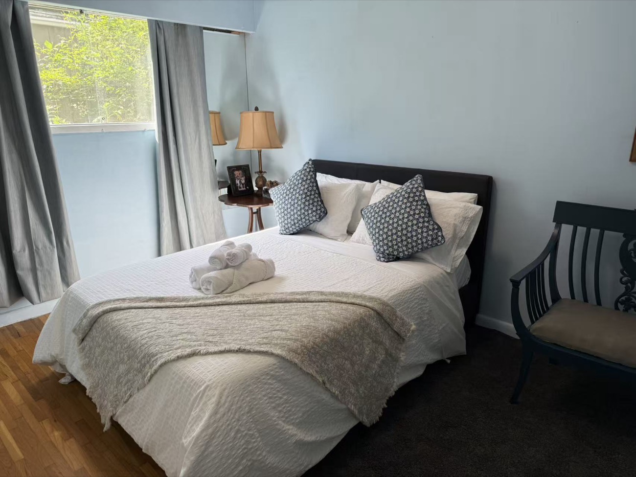 Freshly made bed with rolled towels